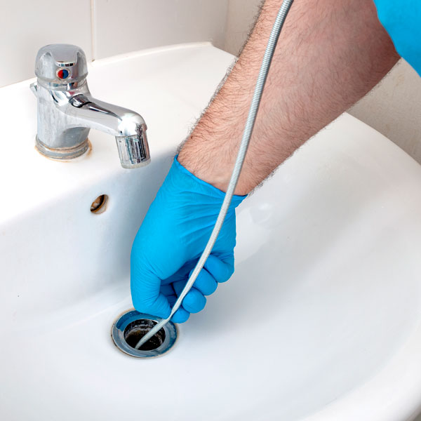 man unclogging sink